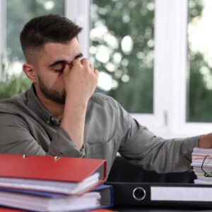 Homeowner reviewing paperwork with visible stress during a delayed home sale in the DC Metro market