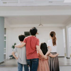 A family from Richmond standing together outside their home with arms around each other, symbolizing stability, togetherness, and a new chapter.